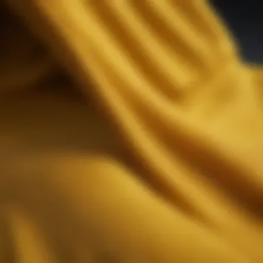 A close-up view of the fabric texture and design details of a yellow hoodie.